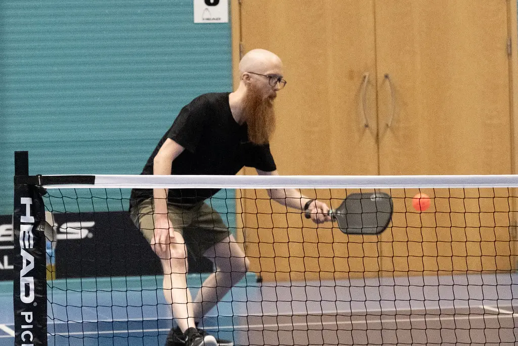 Male player playing in pickleball tournament.
